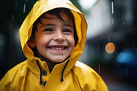 Smiling kid wearing a yellow raincoat portrait photo day. 