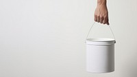 Hand carrying a paint bucket container lighting standing. 