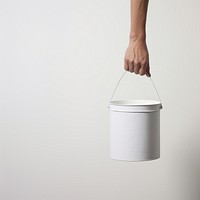 Hand carrying a paint bucket white white background container. 