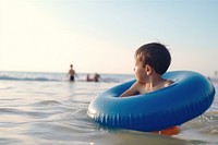 Little boy playing swimming tubing sports. AI generated Image by rawpixel.