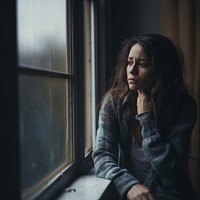 image of sad person looking out window. 