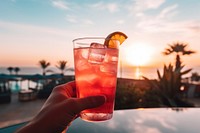 Malibu sunset cocktail outdoors holding mojito. 