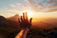 Hand holding sunset mountain outdoors nature. 