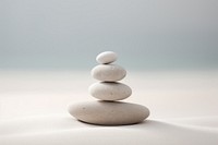 Rocks sitting on top of a white surface on sand pebble pill medication.