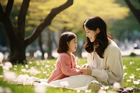 Young asian mother grass sitting child. 