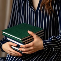 Woman holding stacked books. 