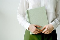 Hand holding a green notebook publication pattern person. AI generated Image by rawpixel.