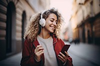 Woman holding mobile phone enjoying music headphones listening adult. 