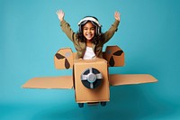 Little girl flying a cardboard airplane. 