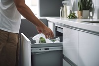 Man sorting garbage dishwasher appliance kitchen. 