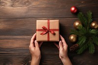 Hands exchanging gift box christmas wood anticipation. 