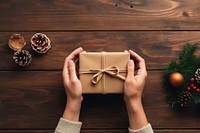 Hands exchanging gift box christmas table wood. 