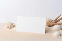 White business card seashell paper sand. 