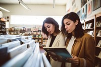 Two hispanic women publication bookstore reading. 