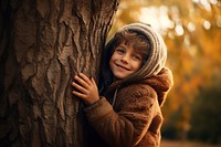 Kid hugging tree smiling happiness innocence. 