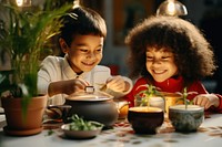 Two diversity kids having hot-pot child food meal. 