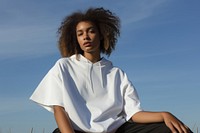 Black woman outdoors sitting white. 