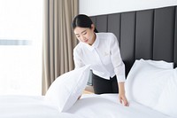 Hotel staff making bed. 