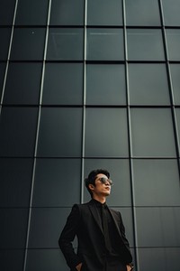 Photo of asian men look up the same way, wear suit and sunglasses.  