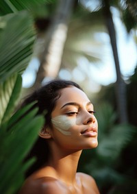 close up side profile photo of a hispanic woman face with subtle pastel green face mask cream.  