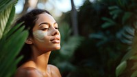 close up side profile photo of a hispanic woman face with subtle pastel green face mask cream.  