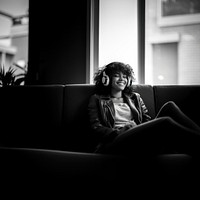 Woman sitting headphones furniture. 