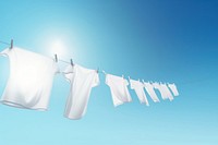 Eco friendly laundry drying on shirt line against a blue sky blackground.  