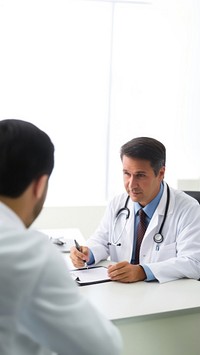 Photo of doctor is talking with patient and making notes while sitting in hospital.  