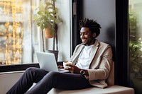 photo of happy african american man drink coffee while working laptop at home.  