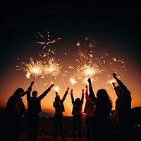 People celebrating New Year fireworks sparkler outdoors. 