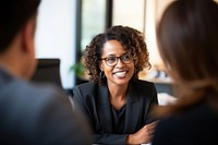 close up photo of a black middle age female lawyer with clients.  