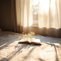 minimal photo of an open book sitting on top of a white sheet.  