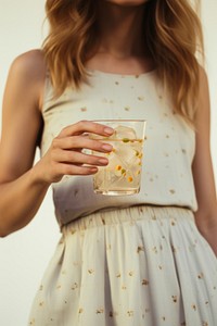 Woman hand holding cocktail drink refreshment midsection. 