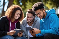 Diverse students computer outdoors reading. 