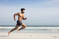 Fit man running jogging shorts beach. 