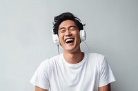 Happy asian man headphones listening shouting. 