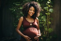 Pregnant black woman smiling holding smile. 