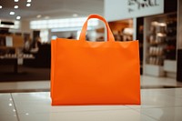 Orange shopping bag handbag consumerism accessories.