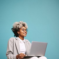 Female looking upward while reading communicating online using silver laptop.  