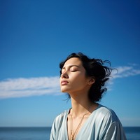 photo of woman praying with bluesky on the sea with blurred vision.  