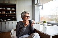 Product photography of a mature woman drinking black coffee while reading newspaper.  