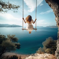 Traveler woman relaxing on swing above sea.  