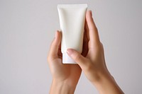 Hand cream tube cosmetics finger white background. 