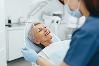 Old female Dentist Treating Teeth Of Woman Patient patient dentist clinic. 