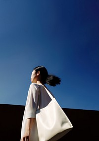 Asian woman holding a big tote bag handbag adult day. 