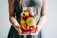 Woman holding fruit drink. 