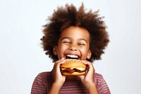 Cute little african boy enjoy eating a hamburger have fun biting child food. 