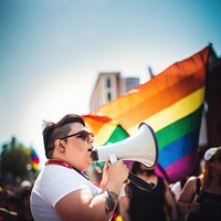 photo of plus size mexican lesbian woman using a megaphone at a pride parade.  