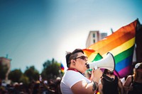 photo of plus size mexican lesbian woman using a megaphone at a pride parade.  