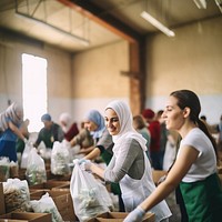 Photo of female volunteers sorting food donations in community center. 